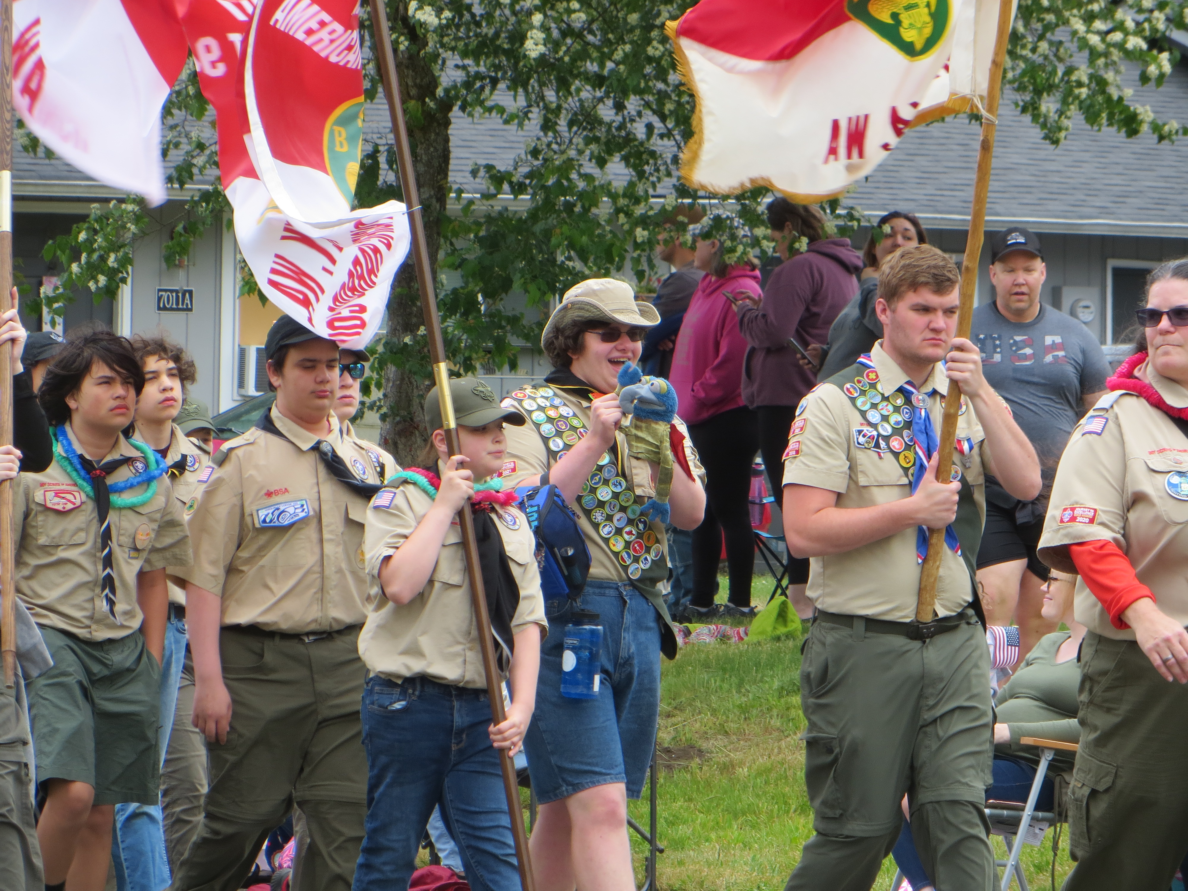 Scouts walking down a road in a parade.