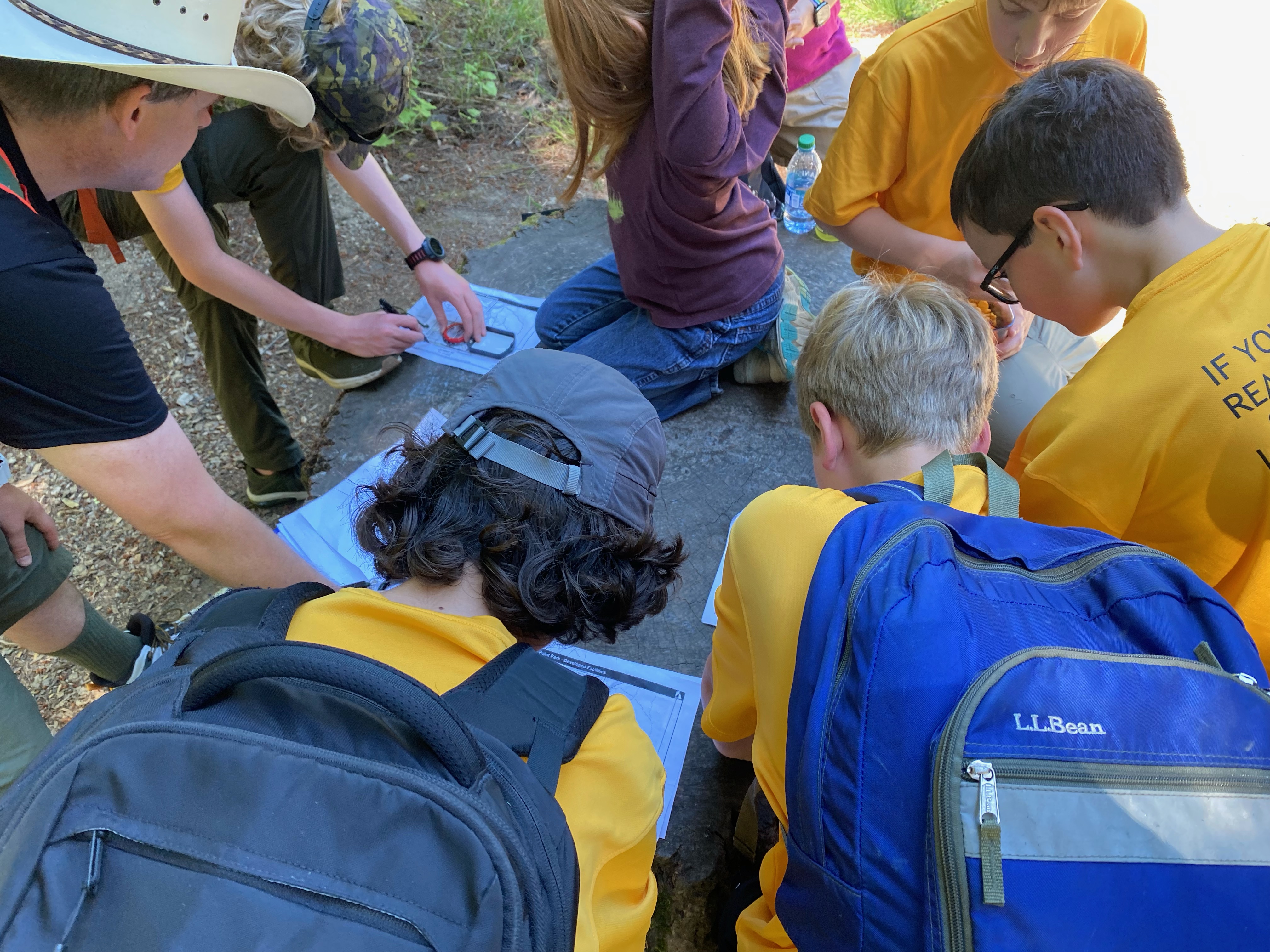 Scouts leaning in a circle using a map and compass.