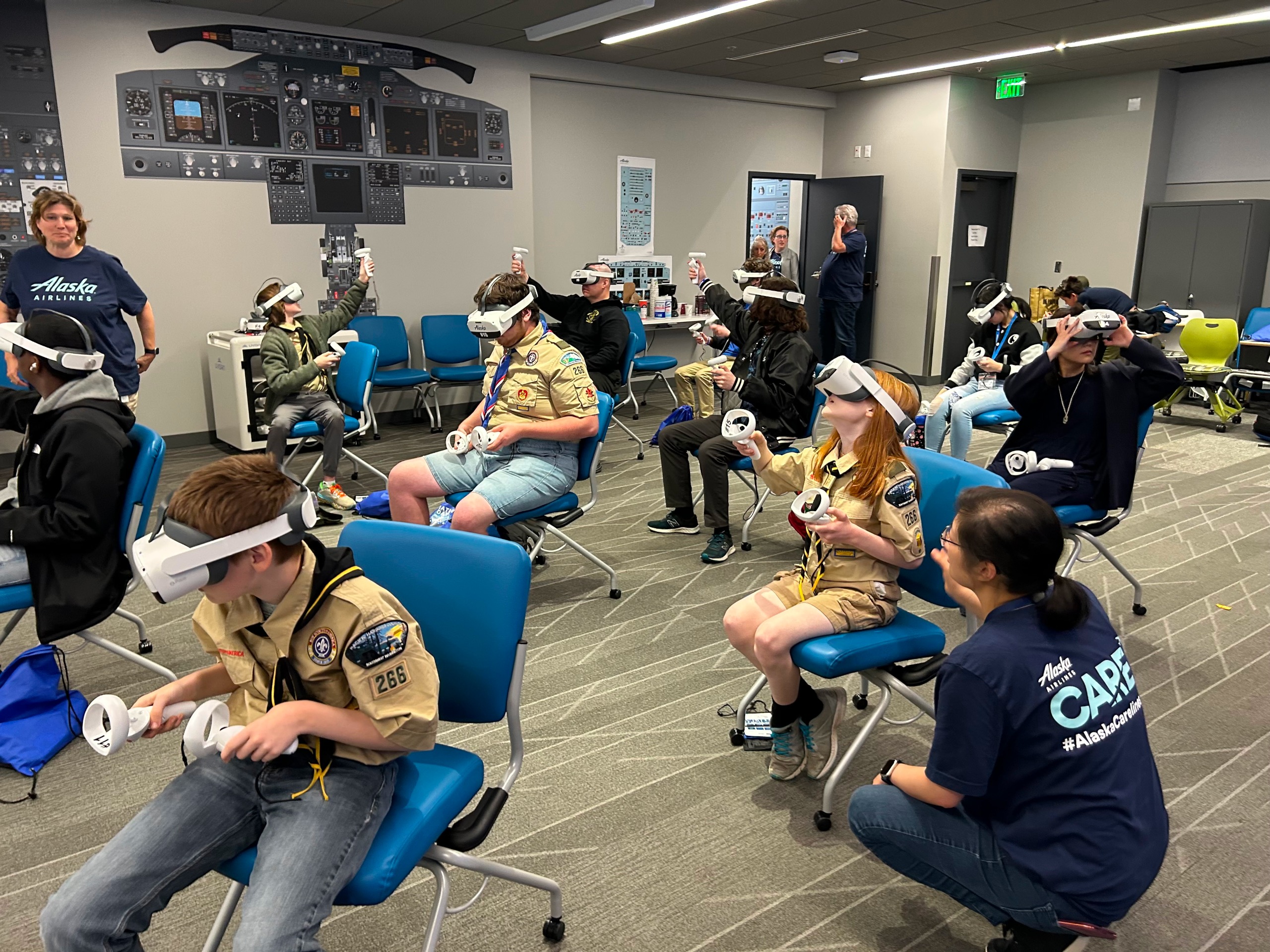 Scouts sitting in chairs using VR headsets.
