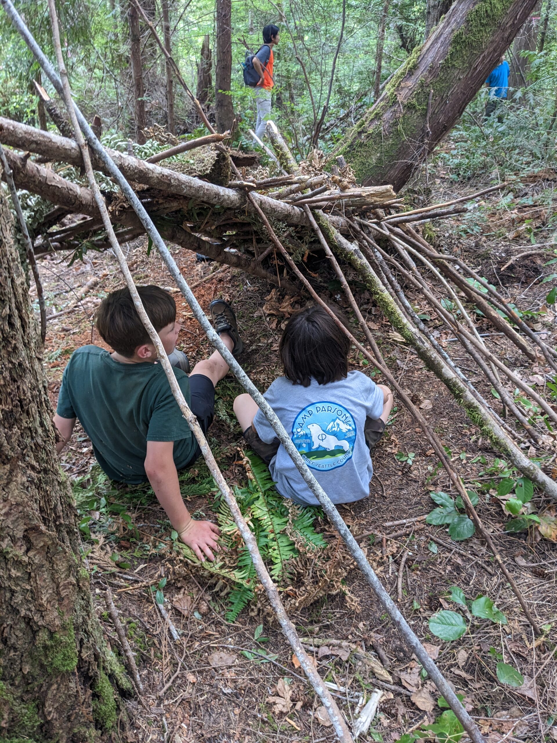 Scouts sitting in a survival shelter