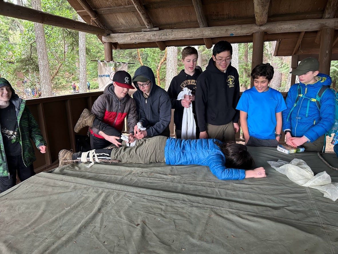 Scouts doing first aid on another scout